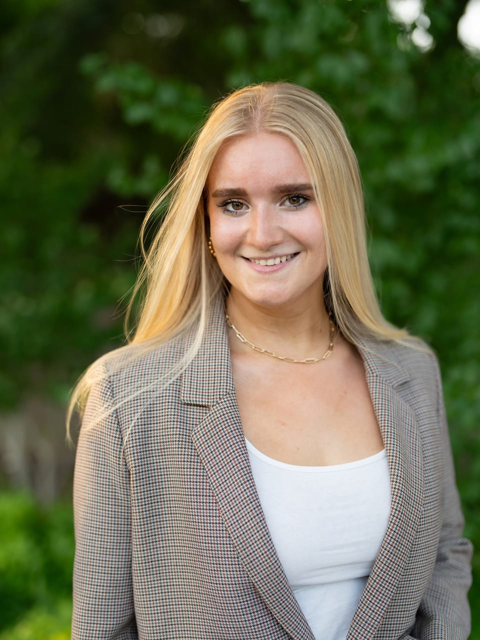 Carson Miller, photographed outdoors in a checked blazer.